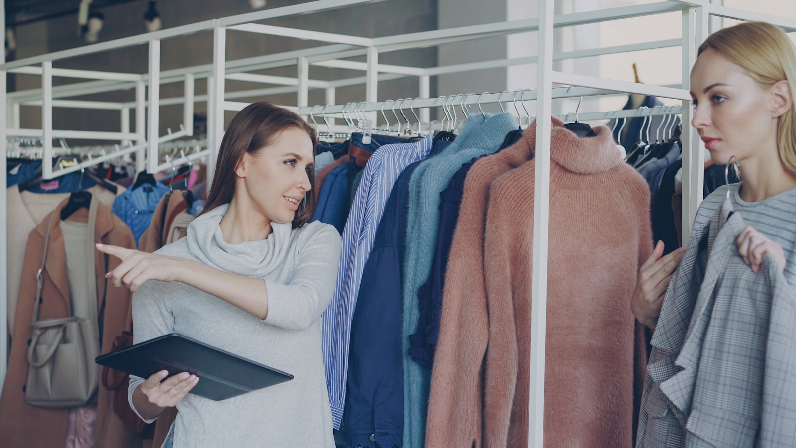 Vendeuse conseillant une cliente dans les rayons d'une unit&eacute; commerciale